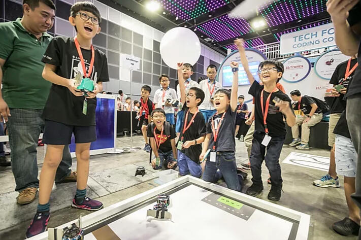 A group of young boys cheering for their teammate at the Zenitant's annual 3D-Tronics Competition, a OSF Funded Project