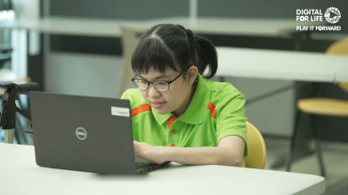 girl in green polo shirt using a laptop