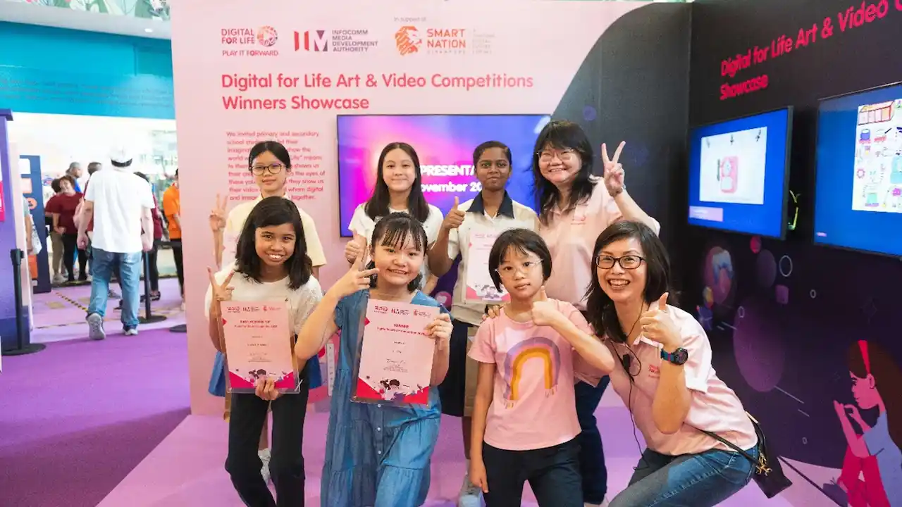 Winners from the Digital for Life Art and Video Competitions 2024, pictured with their prizes and certificates, against a display.