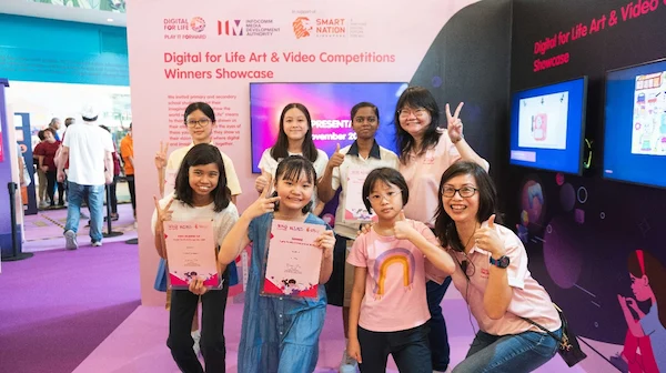Winners from the Digital for Life Art and Video Competitions 2024, pictured with their prizes and certificates, against a display.