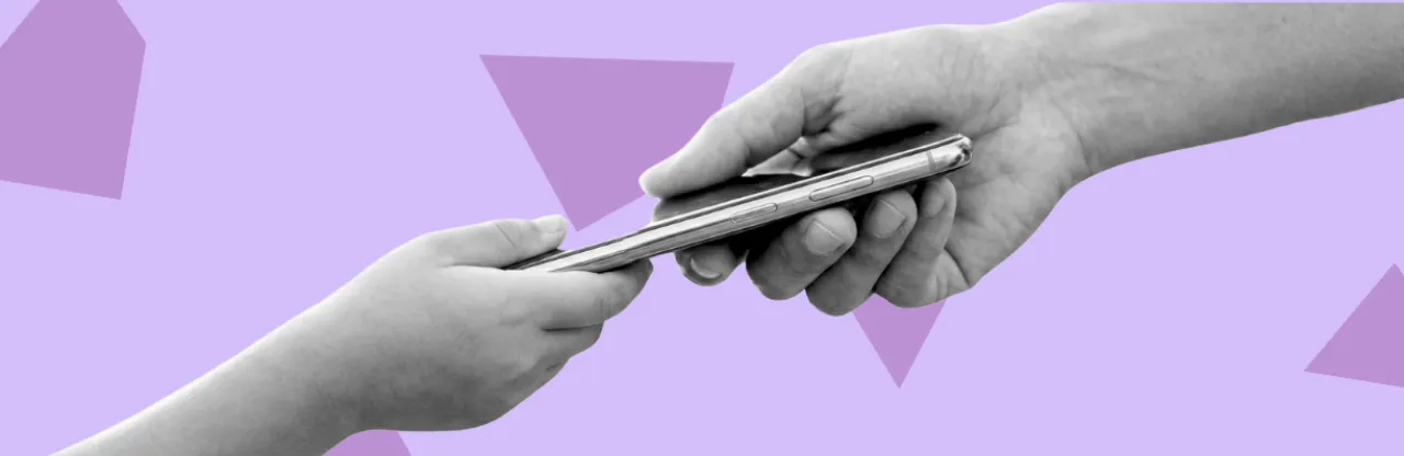 An adult handing phone to a child