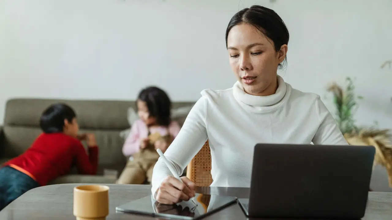 A mother curating content using tablet and laptop. 