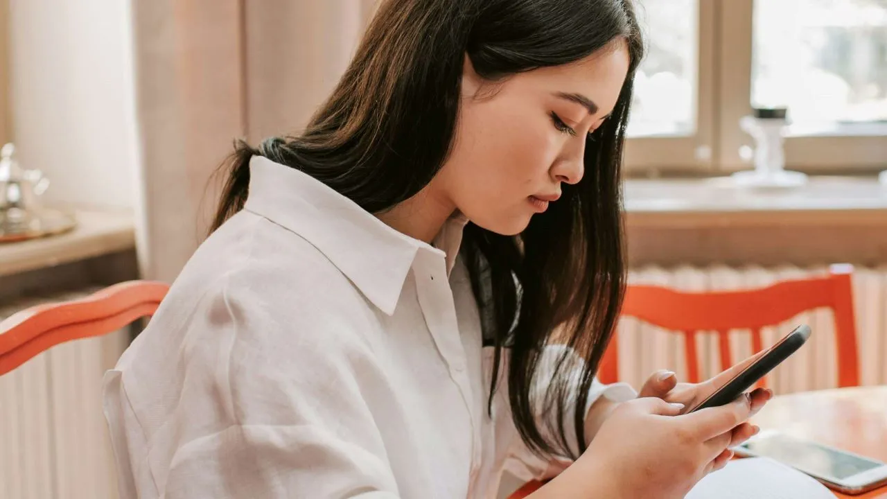 A woman reporting inappropriate content on her phone. 