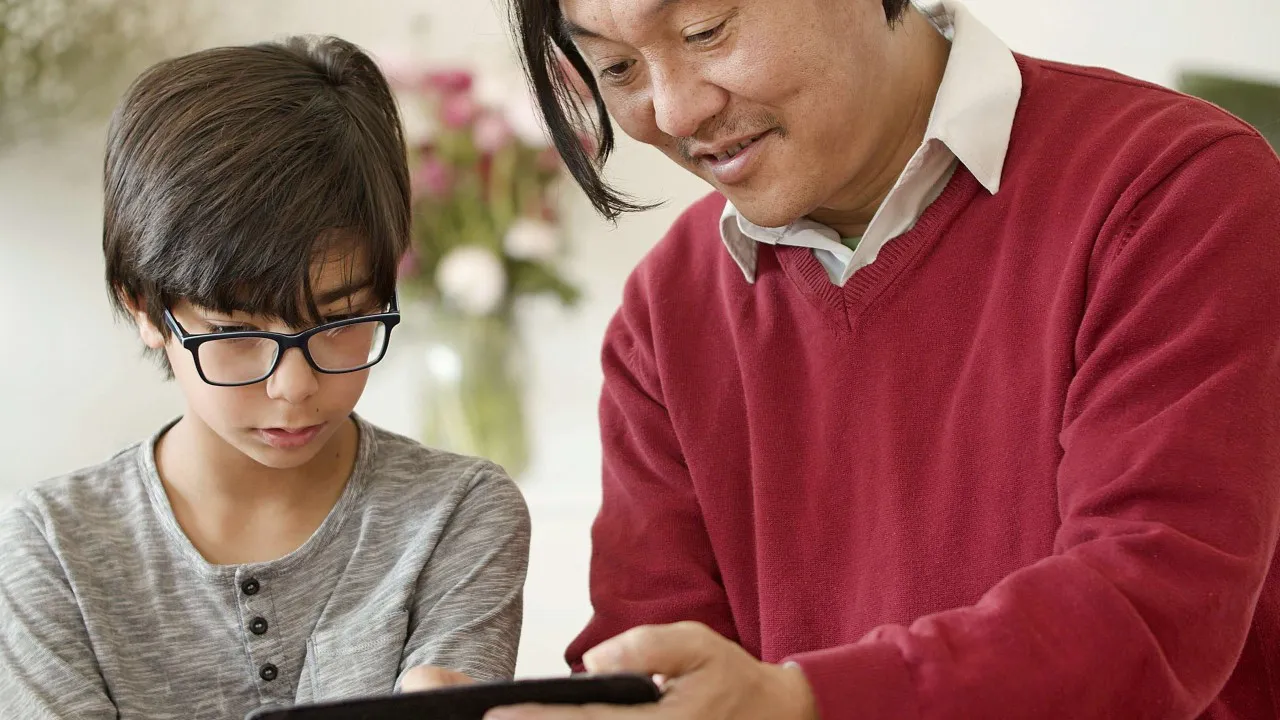 A father guiding his chid on setting boundaries online.