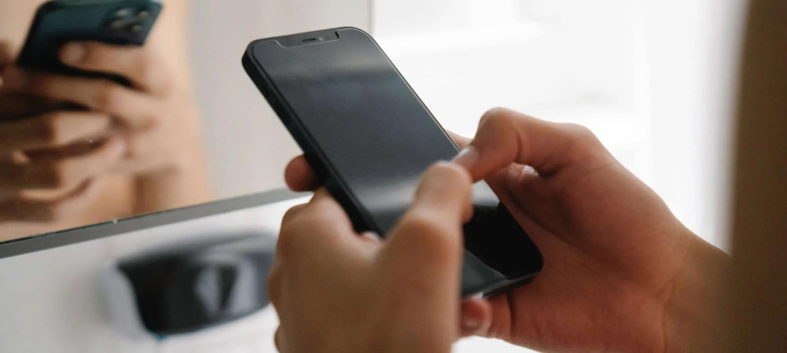 A close-up of a person typing on a smartphone.
