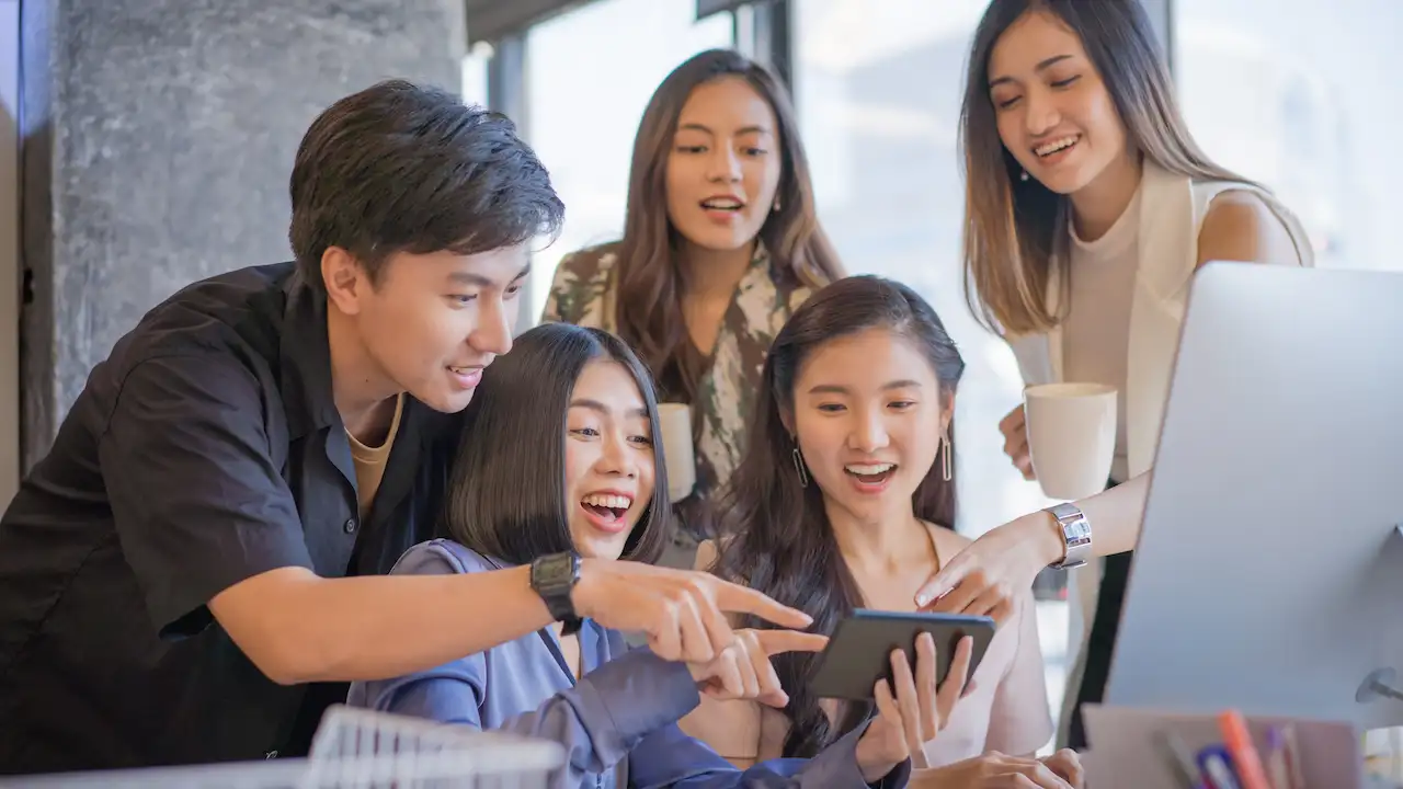 Group of Asian youths on device