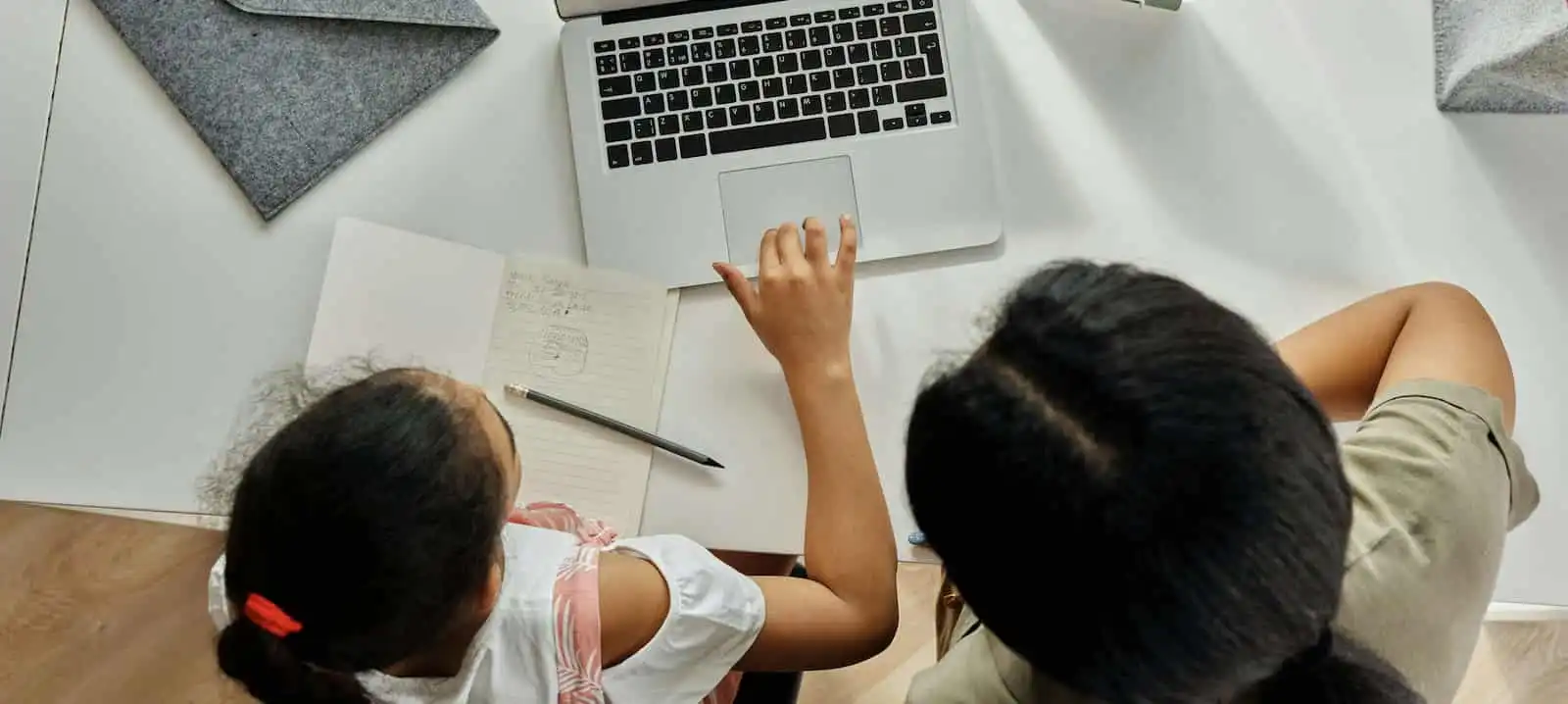 Teacher or educator engaging with students or a child looking distressed in front of a laptop.