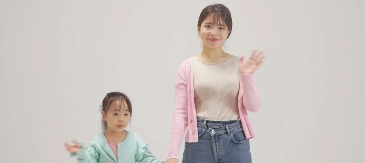 A woman and a girl waving.